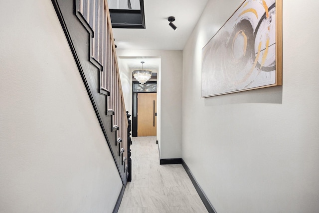 hall featuring an inviting chandelier