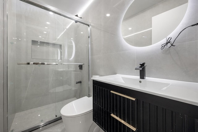 bathroom with vanity, an enclosed shower, tile walls, and toilet