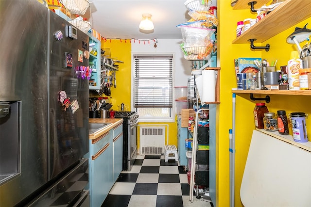 kitchen with radiator heating unit, dark floors, and stainless steel appliances