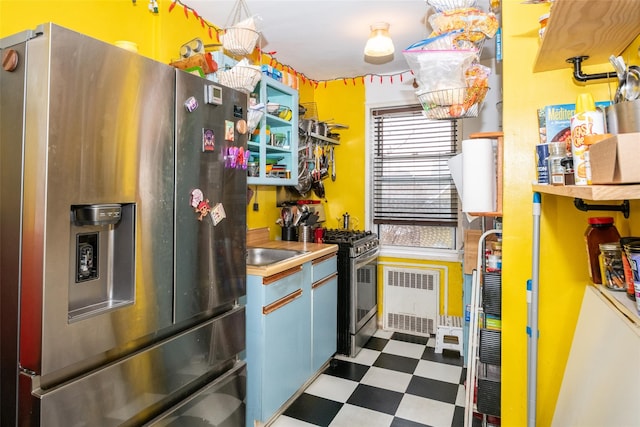 kitchen featuring stainless steel appliances, dark floors, and radiator