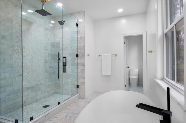 bathroom with baseboards, toilet, a freestanding bath, a shower stall, and recessed lighting