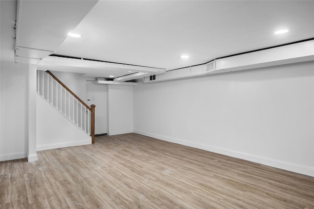 finished below grade area with stairway, recessed lighting, wood finished floors, and baseboards