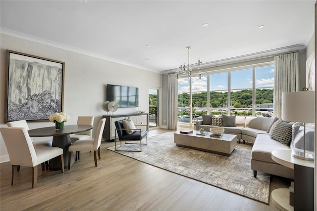 living room featuring a healthy amount of sunlight, ornamental molding, hardwood / wood-style floors, and a notable chandelier