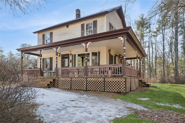 view of front of house with a front yard, covered porch, and a chimney