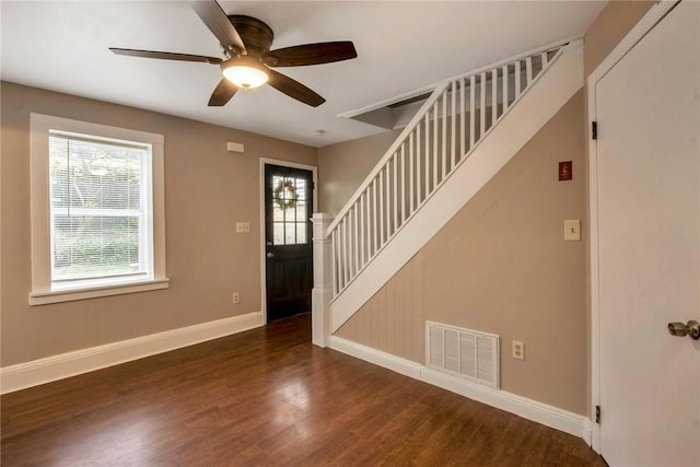 foyer entrance with visible vents, a ceiling fan, wood finished floors, stairway, and baseboards