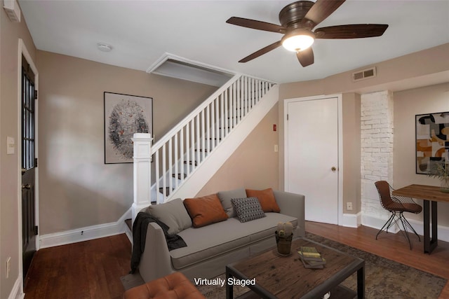 living room with wood finished floors, baseboards, visible vents, ceiling fan, and stairs