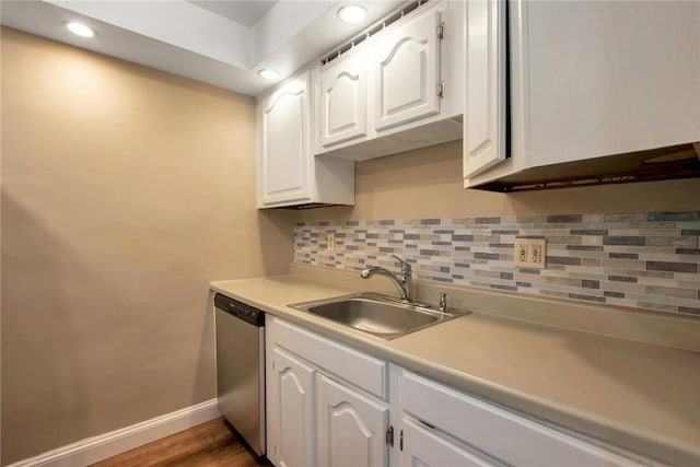 kitchen featuring tasteful backsplash, baseboards, stainless steel dishwasher, white cabinetry, and a sink