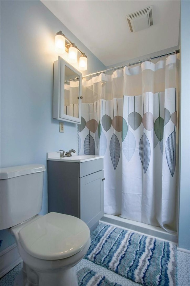 full bathroom featuring vanity, curtained shower, toilet, and visible vents