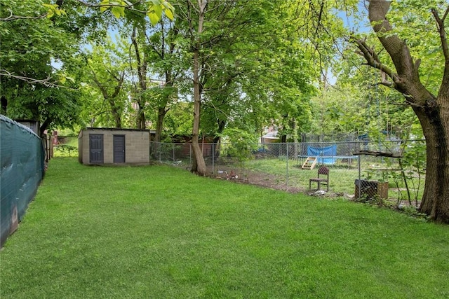 view of yard with an outbuilding, a fenced backyard, and a storage shed