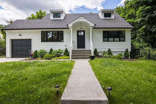 view of front of property with a garage, a front yard, roof with shingles, and fence