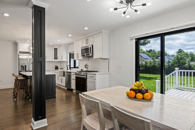 kitchen with stainless steel appliances, tasteful backsplash, light countertops, and white cabinets