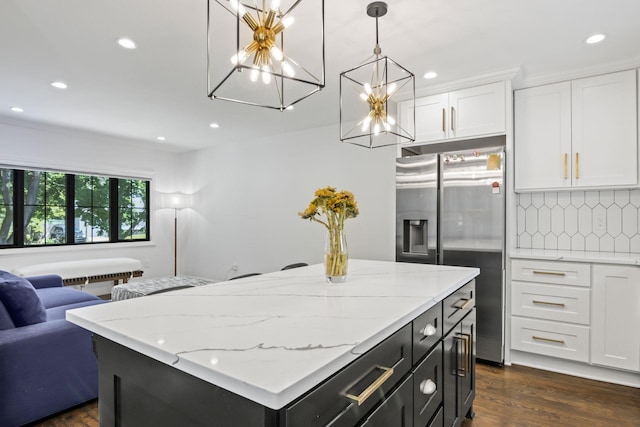 kitchen featuring white cabinetry, open floor plan, decorative backsplash, dark wood-style floors, and stainless steel fridge