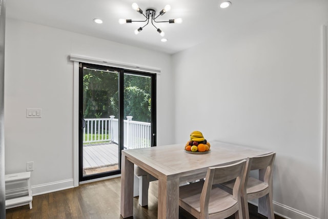 dining area with baseboards, plenty of natural light, wood finished floors, and a notable chandelier