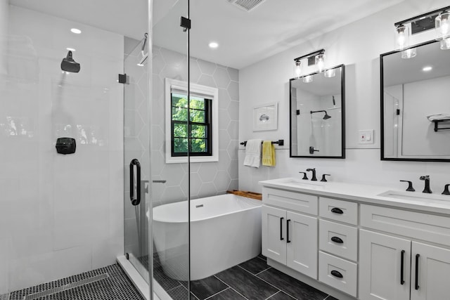 bathroom with a sink, tile walls, a soaking tub, double vanity, and a stall shower