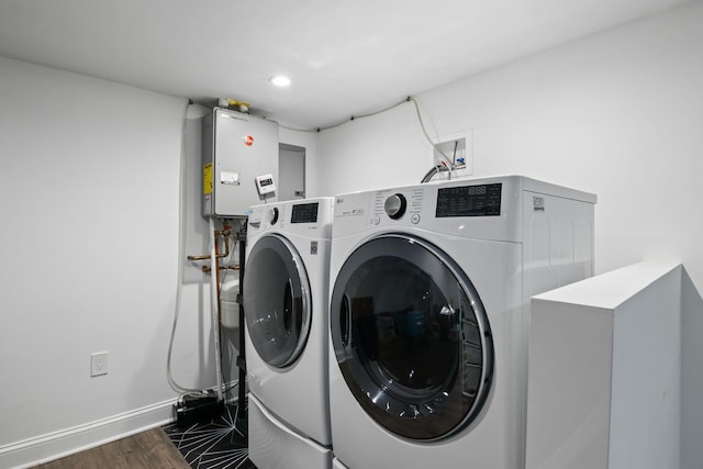 laundry area featuring laundry area, separate washer and dryer, baseboards, water heater, and dark wood finished floors