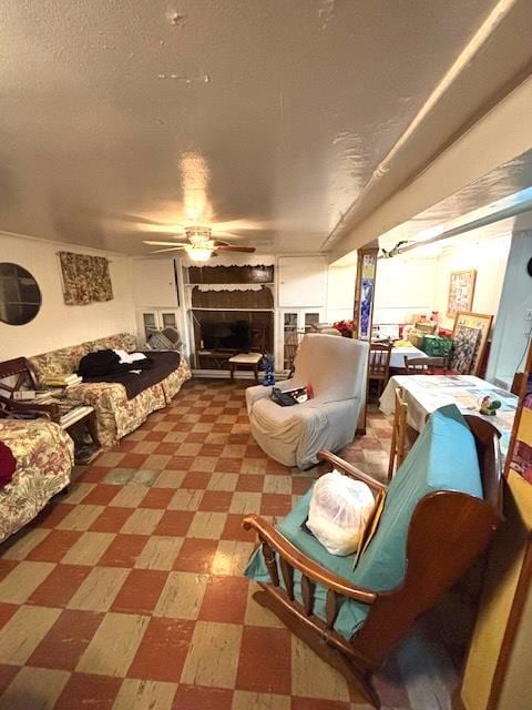 living room featuring a textured ceiling and ceiling fan