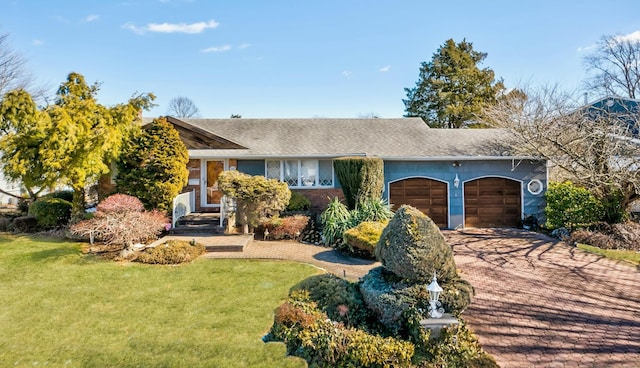 ranch-style house featuring a garage and a front lawn