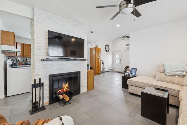 living area featuring light tile patterned floors, lofted ceiling, a baseboard radiator, ceiling fan, and a fireplace