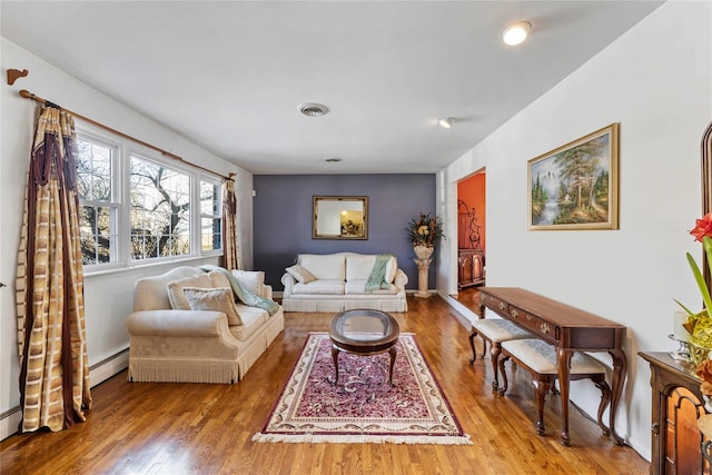 living room with a baseboard radiator and light wood-type flooring