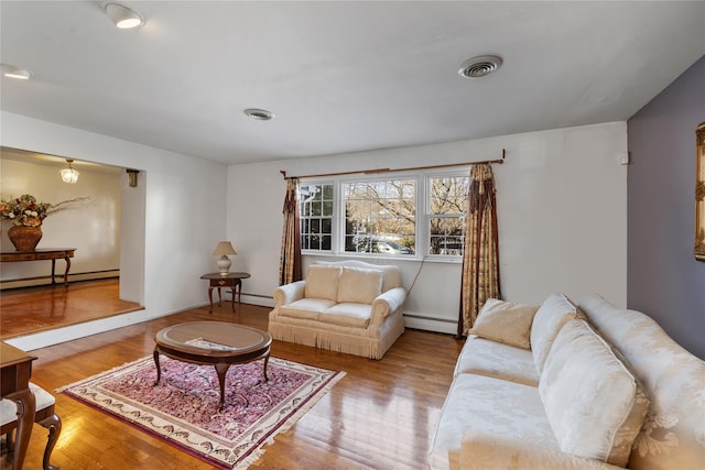 living room featuring light wood-type flooring and a baseboard heating unit