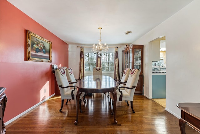 dining area with hardwood / wood-style flooring and a chandelier