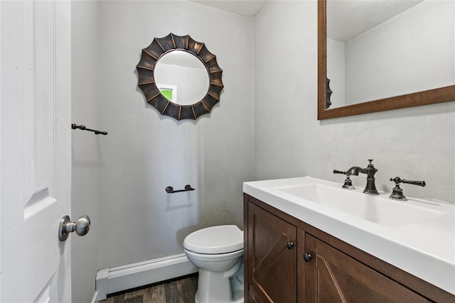 bathroom featuring vanity, a baseboard heating unit, hardwood / wood-style flooring, and toilet