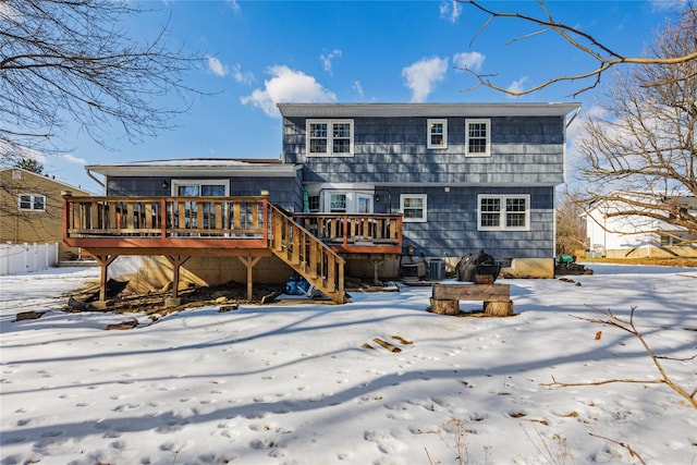 snow covered back of property featuring a wooden deck and cooling unit