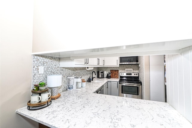 2355 Pershing Blvd Unit 712, Baldwin, NY 11510 - kitchen featuring sink, tasteful backsplash, white cabinetry, kitchen peninsula, and stainless steel appliances
