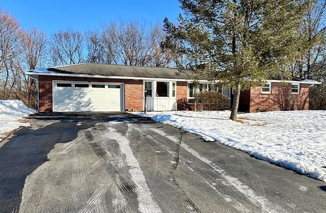 ranch-style home with a garage, driveway, and brick siding