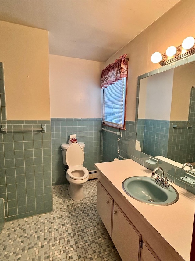 bathroom featuring wainscoting, toilet, a baseboard radiator, vanity, and tile walls