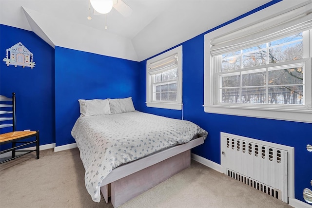 bedroom with multiple windows, light carpet, and radiator heating unit