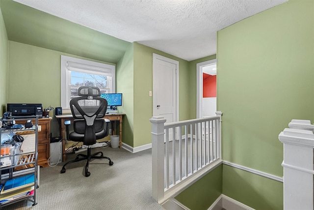 carpeted home office featuring a textured ceiling