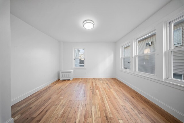 empty room with radiator and light wood-type flooring