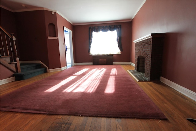 unfurnished living room with crown molding, wood-type flooring, and a fireplace