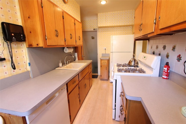 kitchen featuring sink, decorative backsplash, white appliances, and light hardwood / wood-style floors