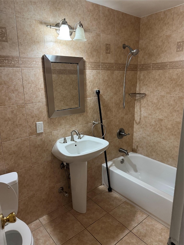 full bathroom with tiled shower / bath, sink, tile walls, tile patterned flooring, and toilet