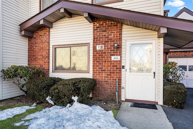 view of exterior entry featuring brick siding