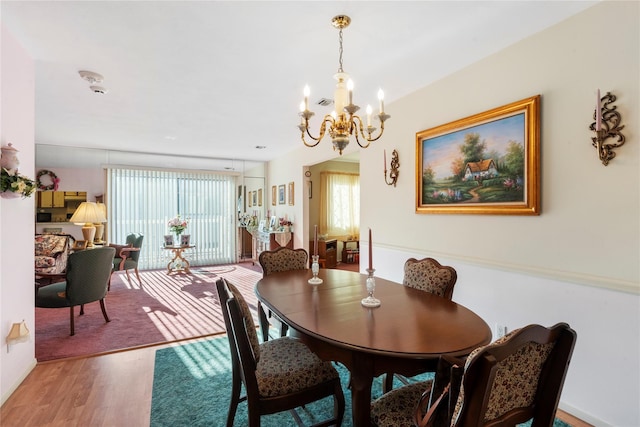 dining room featuring a chandelier, visible vents, and wood finished floors