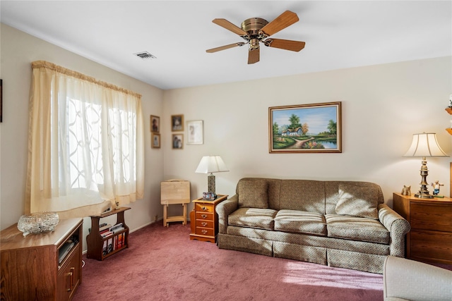 carpeted living room with ceiling fan and visible vents