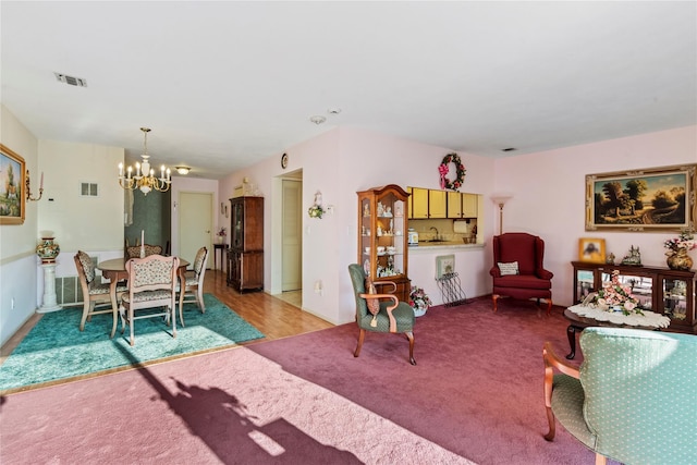 living room featuring light carpet, a notable chandelier, and visible vents