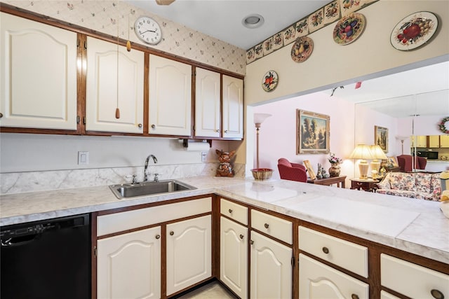 kitchen featuring black dishwasher, light countertops, open floor plan, a sink, and a peninsula