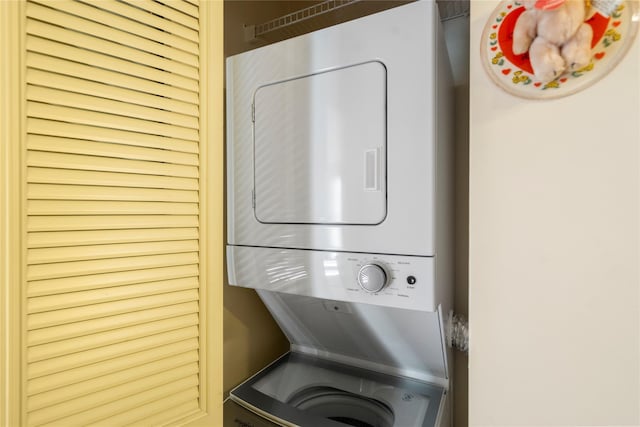 clothes washing area with stacked washer and dryer and laundry area