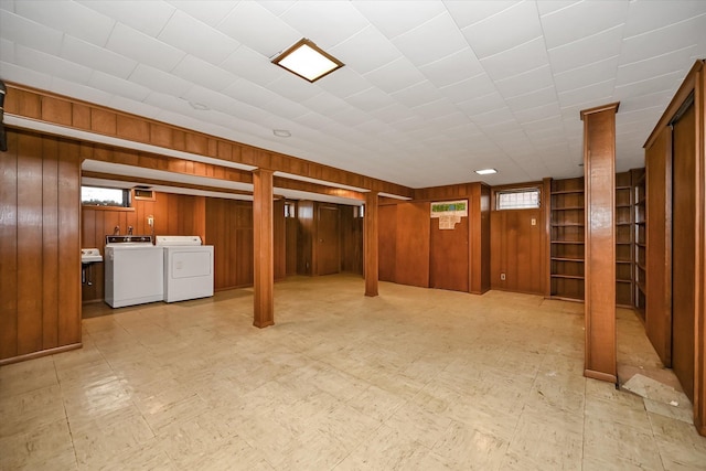 basement with wooden walls and independent washer and dryer