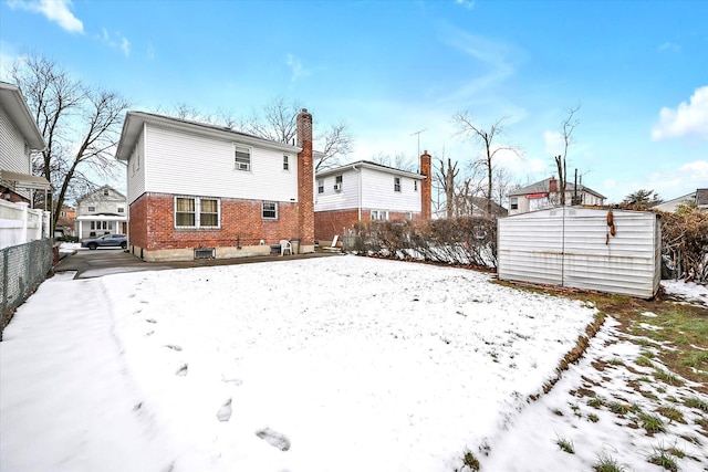 view of snow covered back of property