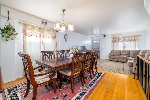 dining space featuring wood-type flooring and a chandelier