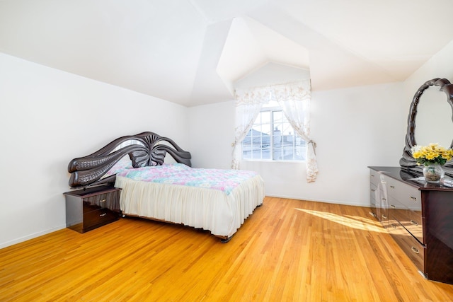 bedroom with light hardwood / wood-style flooring and vaulted ceiling