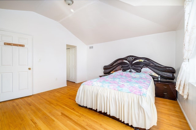 bedroom featuring lofted ceiling and light hardwood / wood-style floors