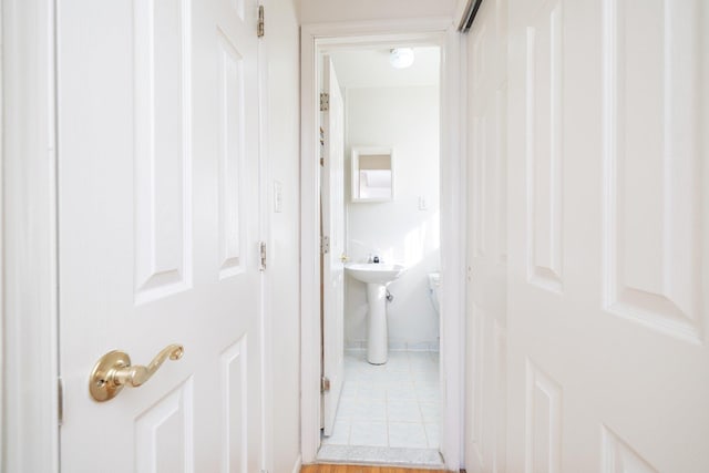 hall with light tile patterned floors and sink