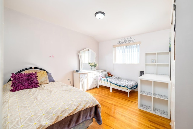 bedroom featuring wood-type flooring and vaulted ceiling