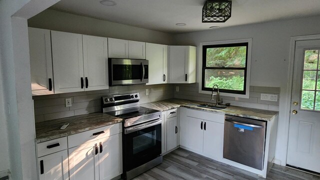 4030 Old Rte 22, Brewster, NY 10509 - kitchen featuring appliances with stainless steel finishes, white cabinetry, backsplash, and wood finished floors